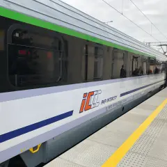 Nowy, lśniący pociąg PKP Intercity stoi na peronie.