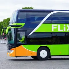 Flixbus: czy można kupić bilet u kierowcy? Dwupiętrowy autokar Flixbus z zielonym logo na tle drzew i ulicy.