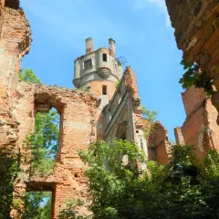 Ruiny zamku, gdzie kamień krajeński wciąż opowiada historie. Widać wieżę i zniszczone mury porośnięte zielenią.