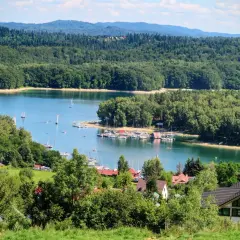 Malowniczy widok na Jezioro Solińskie z żaglówkami i lasami. Idealne miejsce na wakacje, łatwy dojazd samochodem.