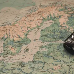 Czarny Fiat 500 na mapie Europy, planujący podróż na Mikołajki do Olsztyna.