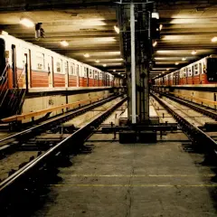 Dwa pociągi stoją na torach w podziemnej stacji metra M1.