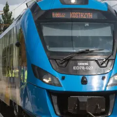 Błękitny pociąg Newag ED78-027 z napisem "Kostrzyn" na wyświetlaczu, gotowy do podróży z Berlina.