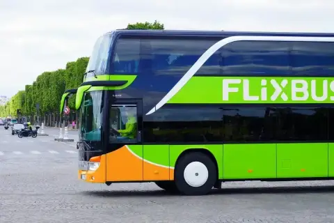Flixbus: czy można kupić bilet u kierowcy? Dwupiętrowy autokar Flixbus z zielonym logo na tle drzew i ulicy.