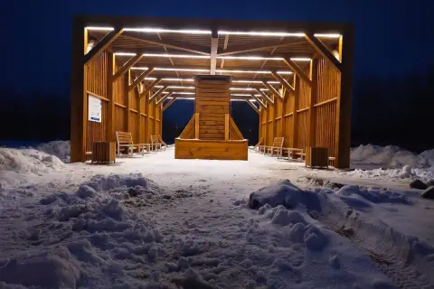 Drewniana tężnia solankowa nocą, otoczona śniegiem. Zastanawiasz się, tężnia solankowa jak często korzystać?