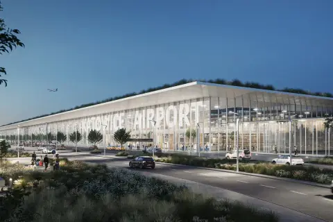 Nowoczesny budynek lotniska Katowice Airport z zielonym dachem i dużymi przeszkleniami. Samolot na niebie, samochody i ludzie przed terminalem.
