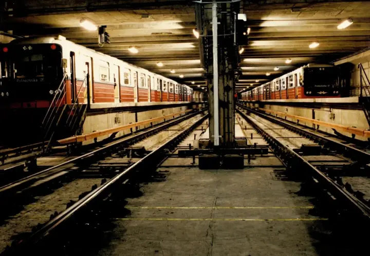 Dwa pociągi stoją na torach w podziemnej stacji metra M1.