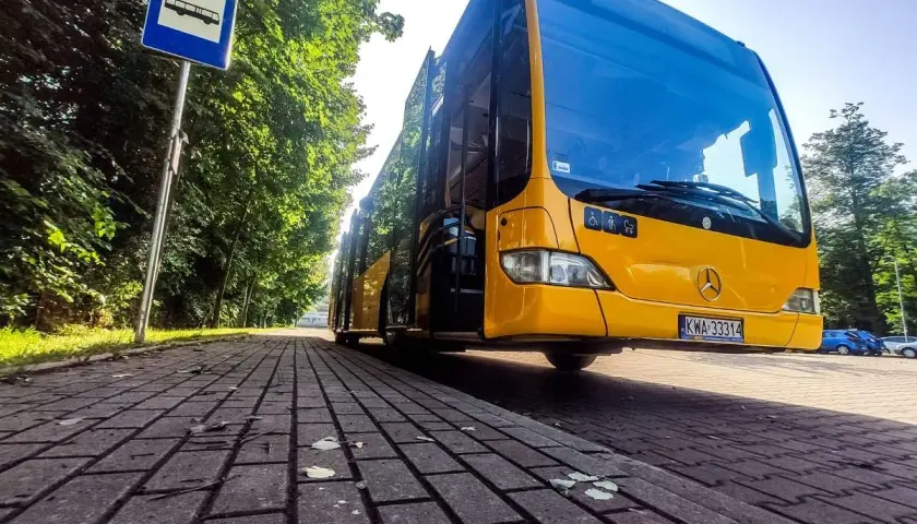 Żółty autobus na przystanku, gotowy do podróży z Krakowa do Zabrza.