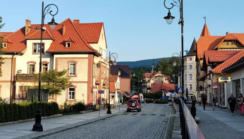 Urokliwa ulica w Świeradowie-Zdroju, z kamienną nawierzchnią i zabytkowymi kamienicami. Idealne miejsce na spacer po uzdrowisku, które przypomina krajobraz z Jeleniej Góry.