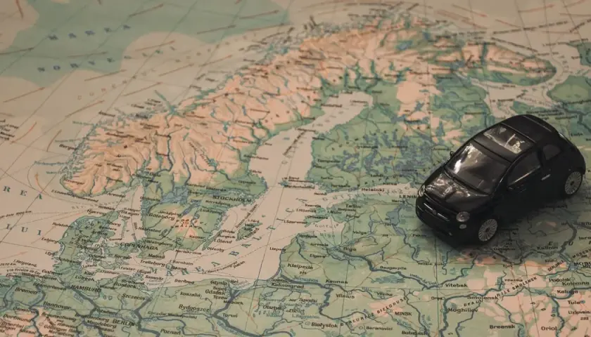 Czarny Fiat 500 na mapie Europy, planujący podróż na Mikołajki do Olsztyna.