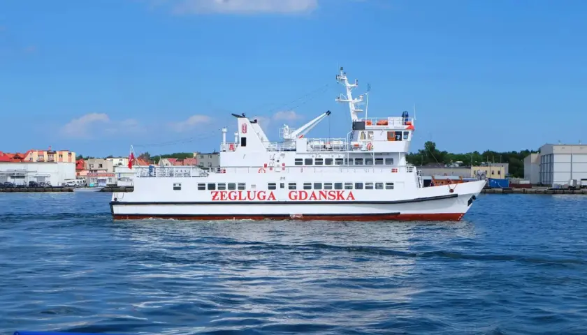 Biały statek pasażerski "Żegluga Gdańska" płynie po wodzie. Sprawdź pkp gdynia - hel cena biletu na rejs.