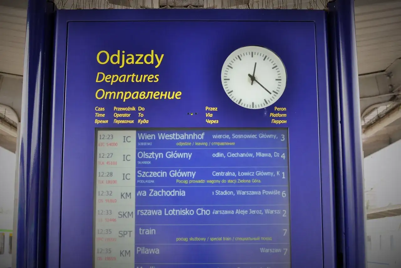 Tablica odjazdów PKP, kiedy zmiana rozkładu jazdy PKP. Zegar wskazuje godzinę, a lista pociągów pokazuje kierunki i czasy odjazdów.