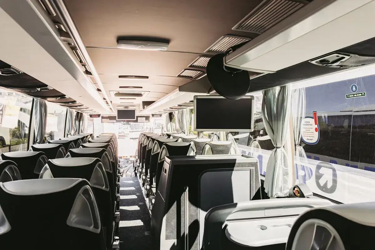 Wnętrze autobusu, gotowego na podróż z Krakowa do Mszany. Puste siedzenia czekają na pasażerów.